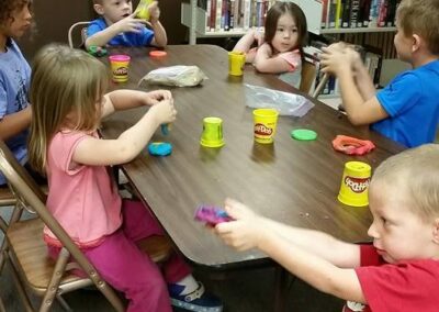 Children sitting at a table playing with PlayDoh